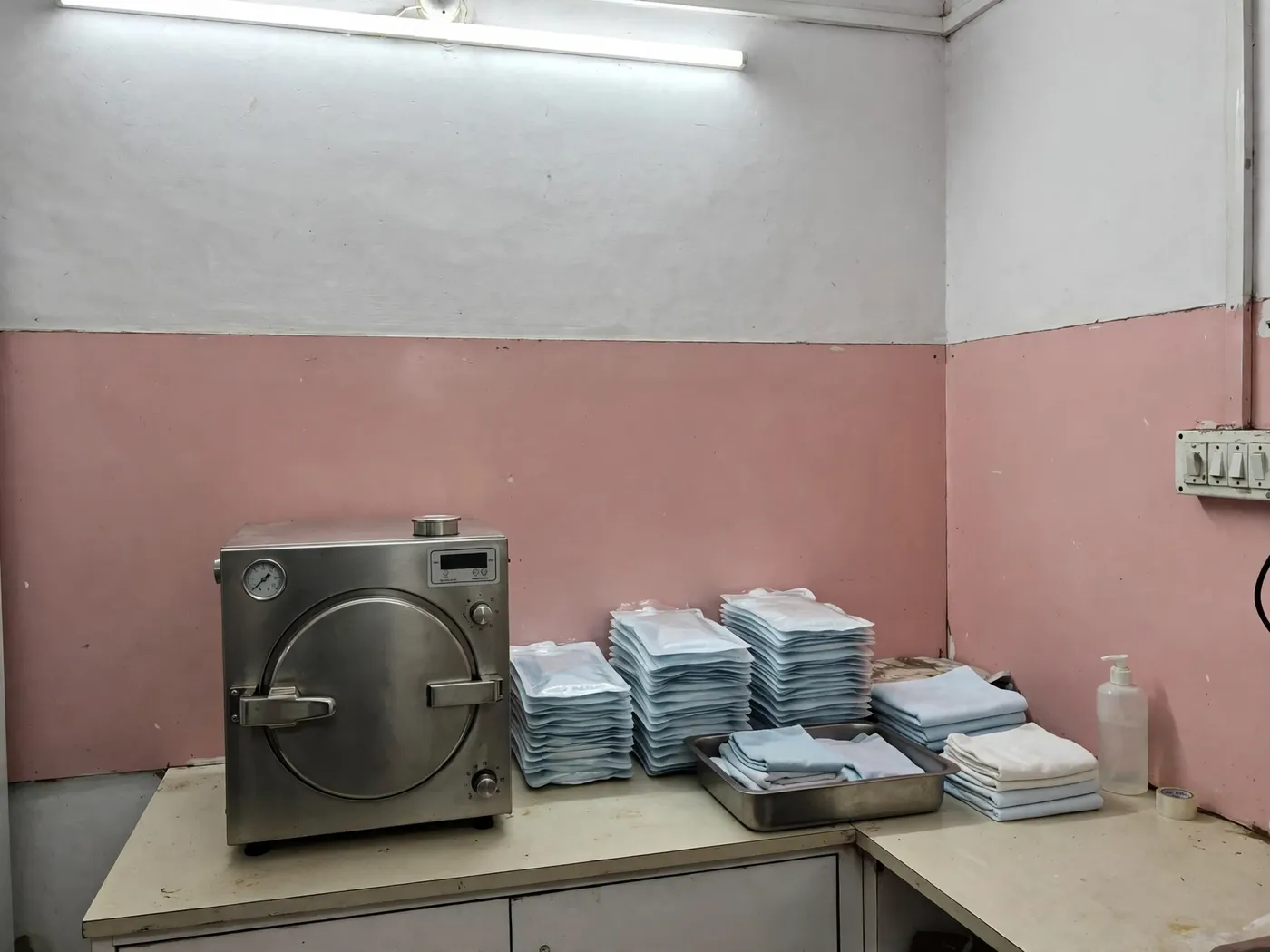 The autoclave with sealed instrument pouches stacked beside it