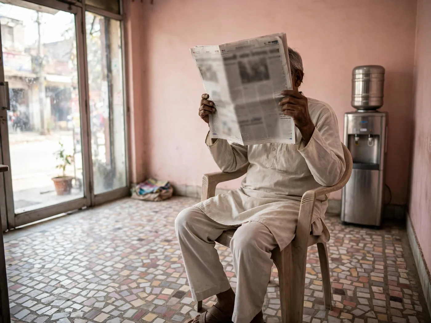 A patient reading a newspaper in the waiting corner